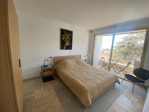 une chambre avec un lit et une grande fenêtre dans l'établissement Cannes vue mer, à Cannes