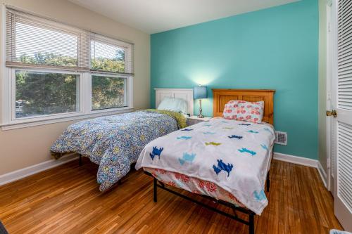 a bedroom with a bed and two windows at Centrally Located Spacious Abode in Charlotte