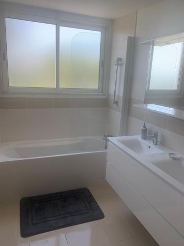 une salle de bain blanche avec une baignoire et un lavabo dans l'établissement Cannes vue mer, à Cannes