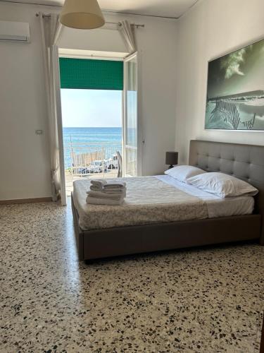 een slaapkamer met een bed en uitzicht op de oceaan bij B&B Mare Colombo in Salerno
