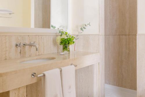 a bathroom with a sink and a vase of flowers at Jumeirah Capri Palace in Anacapri