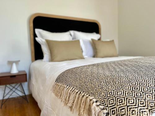 a bed with white sheets and pillows next to a table at Richard Lequet Domaine gastronomique du Val d Atur in Boulazac