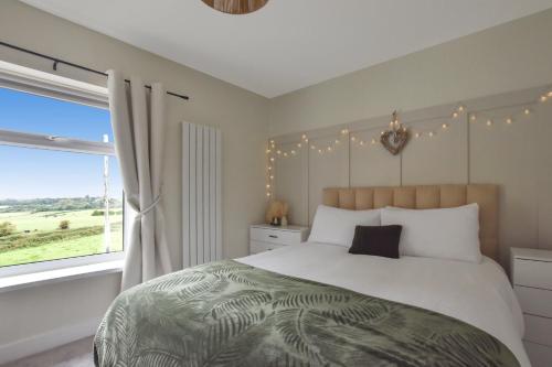 una camera con un grande letto e una finestra di A spacious home from home with spectacular views a Heywood