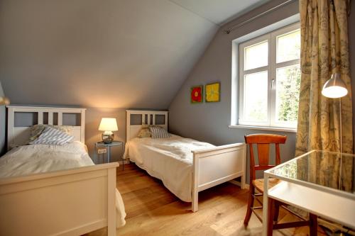 a bedroom with two beds and a table and a window at Landhaus Arcadia in Paretz in Ketzin