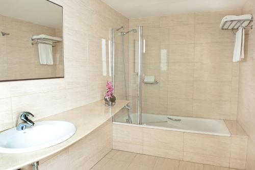 een badkamer met een wastafel, een douche en een bad bij Hotel Duran in Figueres