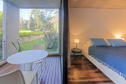 um quarto com uma cama, uma mesa e uma janela em Be House & Spa by Oceana Suites em Punta del Este