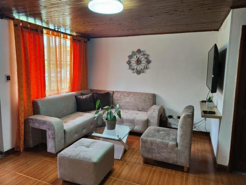a living room with a couch and chairs and a tv at Casa amoblada Dosquebradas in Dosquebradas