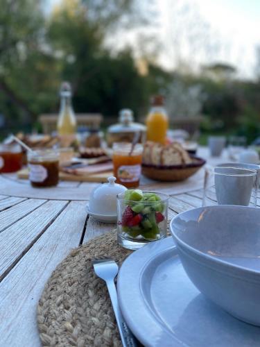 a wooden table with a plate of food on it at Chambres d’hôtes du Presbytère in La Bastide-lʼÉvêque