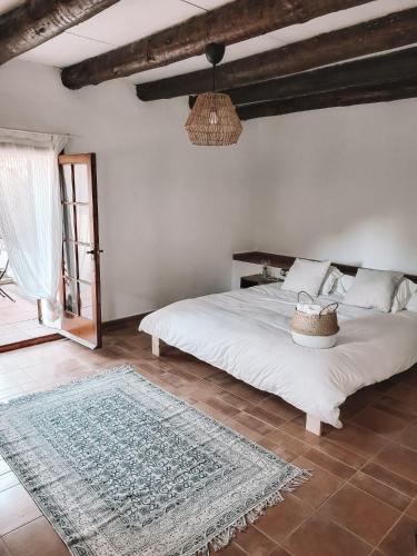 a bedroom with a white bed and a rug at Casa Om in Dosríus