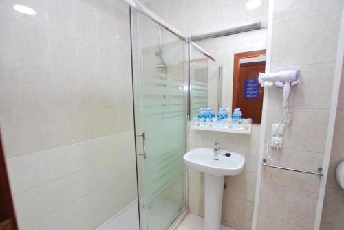 a bathroom with a shower and a sink at Hotel Tres Leones in Vilassar de Mar