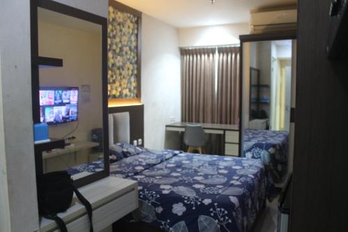 Cette chambre comprend 2 lits et un miroir. dans l'établissement Grand Kamala Lagon Promo Malam, à Pulosirih