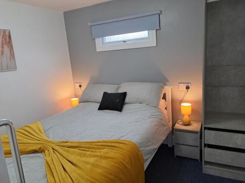 a bedroom with a bed with a yellow blanket at Sandhaven Beach Chalets in South Shields