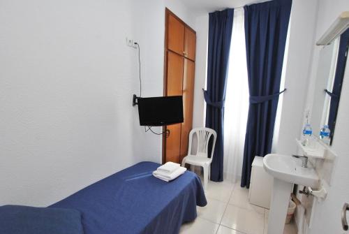 a bedroom with a bed and a sink and a toilet at Hotel Tres Leones in Vilassar de Mar