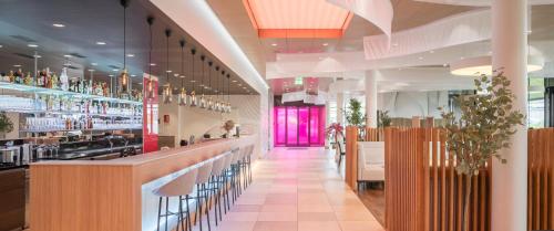 a restaurant with a bar and a pink door at Prize by Radisson, Zurich Affoltern am Albis in Affoltern