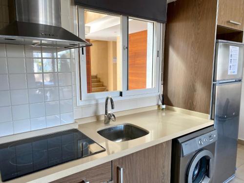 a kitchen with a sink and a dishwasher at Apartamentos Carlton VyB in Denia