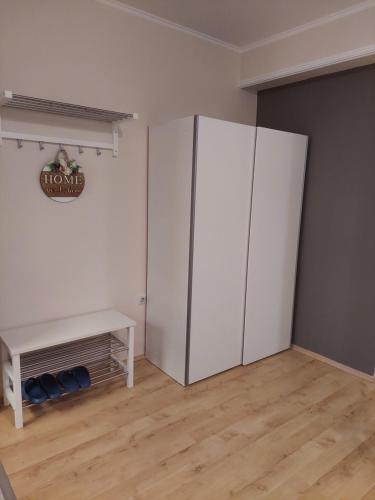 a room with a white refrigerator and a table at Chic Apartment Subotica in Subotica