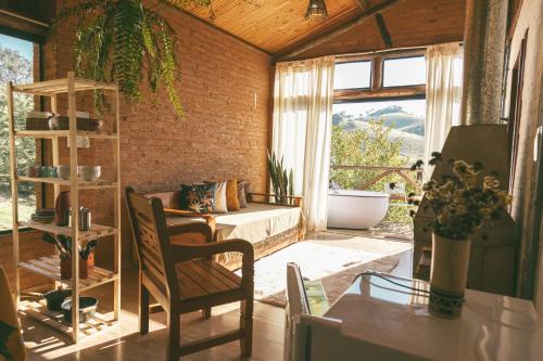 - un salon avec un canapé et une fenêtre dans l'établissement Chalé Gaia com Banheira relaxante, à São Bento do Sapucaí