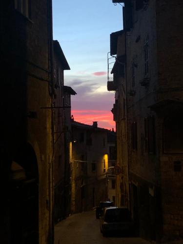 an alley way with a sunset in the distance at Casa Tre Gradini in Perugia