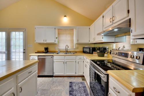 a kitchen with white cabinets and stainless steel appliances at Pet Friendly Charming Cozy Greensboro Gem! in Greensboro