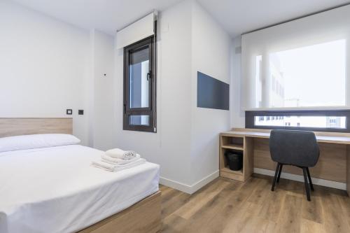 1 dormitorio con escritorio, 1 cama y 1 silla en Micampus Wynwood - Xaudaro, en Madrid