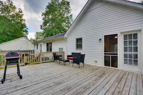 a deck with chairs and a grill on a house at Pet Friendly Charming Cozy Greensboro Gem! in Greensboro