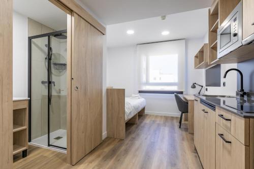 ein Bad mit einem Waschbecken und einer Dusche in einem Zimmer in der Unterkunft Micampus Wynwood - Xaudaro in Madrid