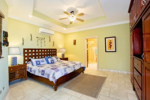 - une chambre avec un lit et un ventilateur de plafond dans l'établissement Casa Q - Bella Vista, à Playa Hermosa