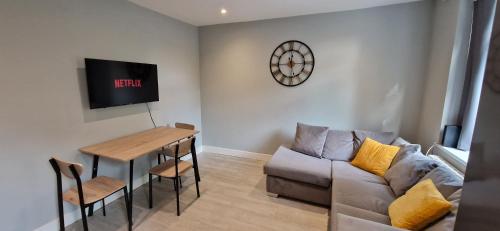 a living room with a couch and a table at Central Reading Modern 3BR flat - Walk to station and high street in Reading