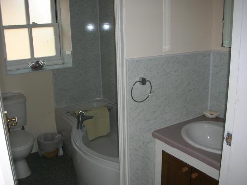 a bathroom with a sink and a tub and a toilet at Watermill Farm Cottages in Metheringham