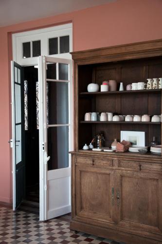 una puerta abierta a una cocina con un armario de madera en La Maison Plûme, en Villequier