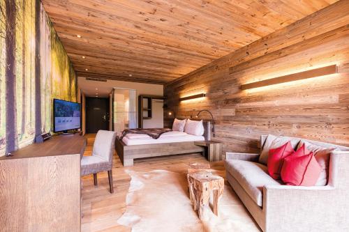 Habitación con pared de madera, sofá y cama. en Riverside, en Zweidlen