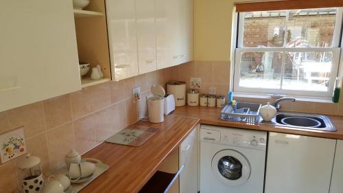 cocina con fregadero y lavadora en Watermill Farm Cottages, en Metheringham