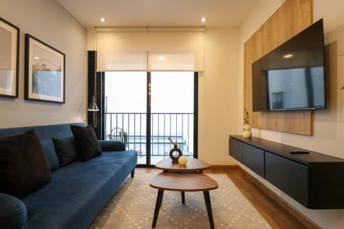 a living room with a blue couch and a tv at Great 2BR with Balcony in the Heart of Miraflores in Lima