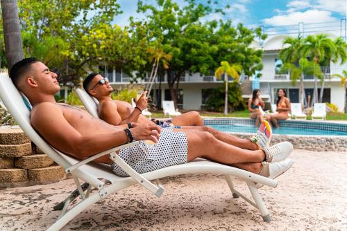 two men sitting in lawn chairs by a pool at Solace by the Sea in Ponce