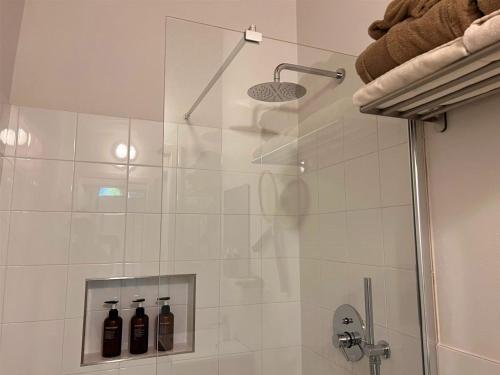 a shower with a glass door with bottles in it at Garibaldina75 in Cesena