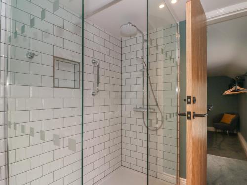 a shower with a glass door in a bathroom at Stillwater Cottage in Beverley