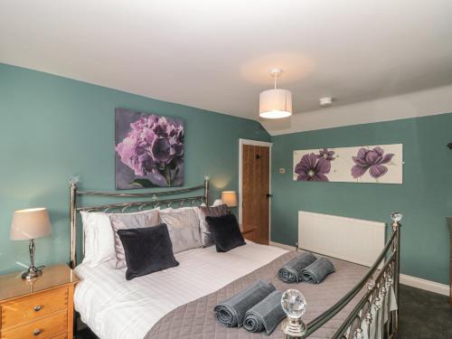 a bedroom with a bed in a room with green walls at Stillwater Cottage in Beverley