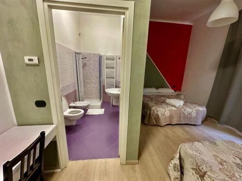 a room with a bathroom with two beds and a toilet at La GLORIA RHO in Rho