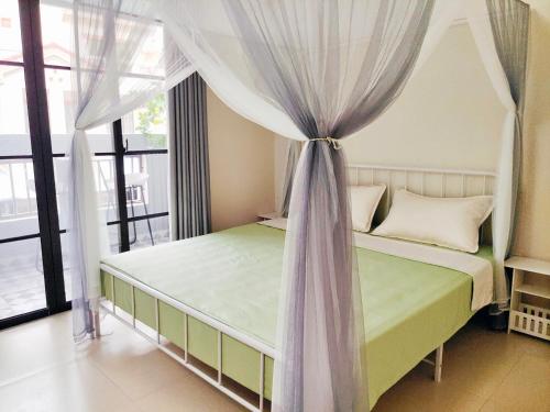 a bedroom with a bed with a canopy at 闲肆民宿 in Sanya