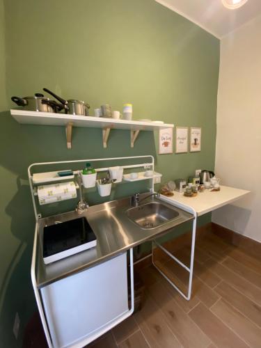 eine Küche mit einem Waschbecken und einem Regal mit Töpfen und Pfannen in der Unterkunft La Casa di LiLù in Taranto