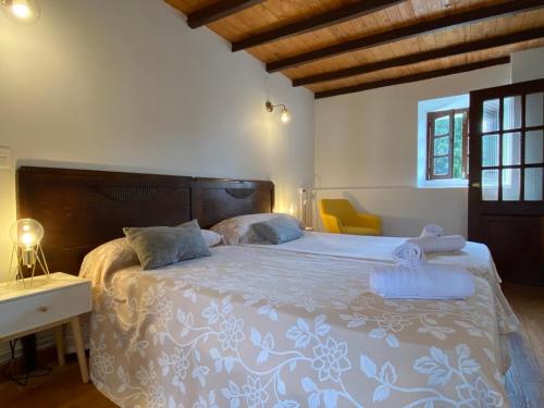 a bedroom with a large bed with a wooden headboard at La Casina de Inesita in Cadavedo