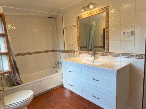 een badkamer met een wastafel, een bad en een toilet bij La Casina de Inesita in Cadavedo