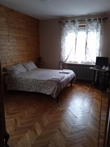 um quarto com uma cama e uma janela em Affittacamere Buca di bacco em Pontechianale