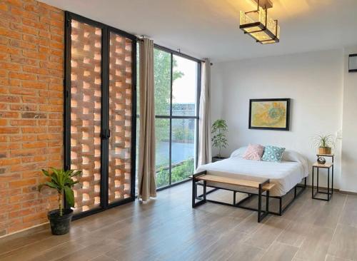 a bedroom with a bed and a brick wall at Hermoso Loft en Santa Anita in Santa Anita