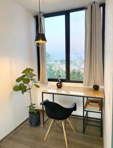 a desk and a chair in a room with a window at Hermoso Loft en Santa Anita in Santa Anita