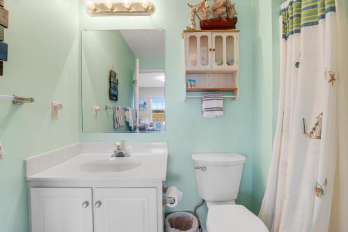 une salle de bain avec un lavabo, des toilettes et un miroir dans l'établissement Bethany Bay -- 37185 Harbor #3602, à Ocean View