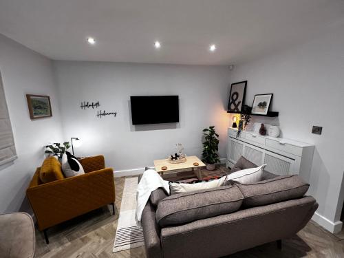 uma sala de estar com um sofá e uma televisão em Holmfirth Hideaway em Holmfirth