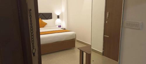 a bedroom with a bed and a door to a room at Hotel Le Grandeur in Bengaluru