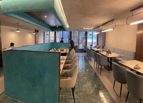 a restaurant with a green wall and tables and chairs at Hotel Le Grandeur in Bengaluru