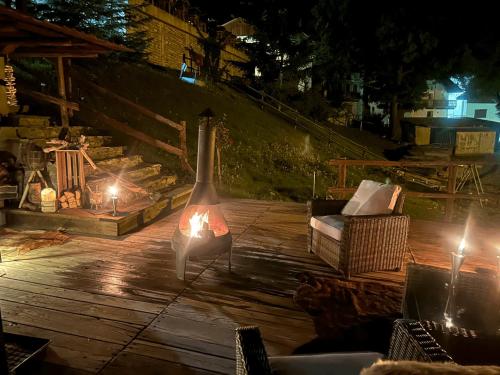 a fireplace on a wooden deck at night at chalet Sestriere in Champlas du Col